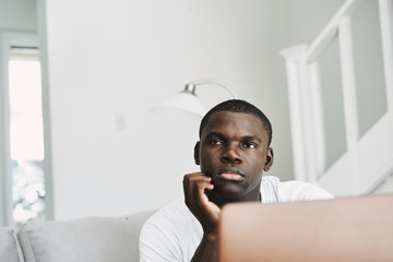 A man of African appearance at home in front of a laptop relaxing communication