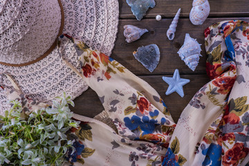 on the table is a women's dress, hat and seashells