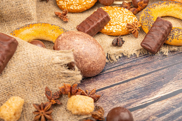 Bagels, chocolate cakes, cookies and chocolate on a background of coarse homespun fabric. Close up.