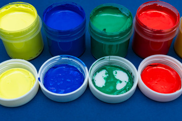 Close up of open multicolored acrylic paint cans.