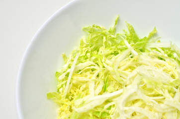 Fresh chinese cabbage salad in bowl on white table background. Vegan food lifestyle.
