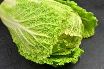 Chinese cabbage on black background. Vegan eco-conscious food concept.