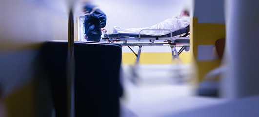 Defocused blur conceptual image of unrecognizable patient on the ward bed hospital corridor during worldwide disease infection by the contagious coronavirus covid-19
