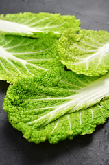 Fresh chinese cabbage leaves on dark background. Vegan food lifestyle.