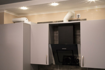 Cooker range hood and ventilation pipe in kitchen furniture.