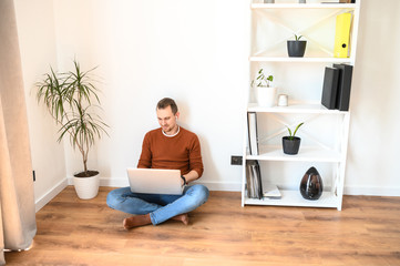 Young guy spends leisure time with a laptop