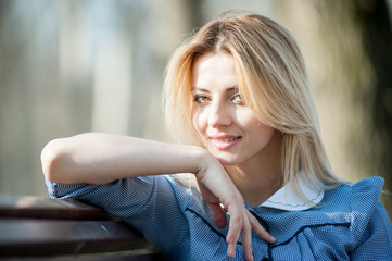 beautiful blonde girl in blue dress enjoys spring