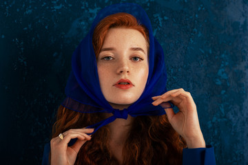 Fashion portrait of elegant redhead woman with freckled skin wearing luxury trendy headscarf,...