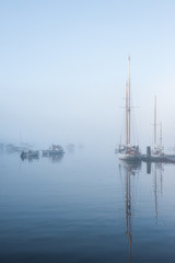 Fototapeta na wymiar Boats Anchored In Foggy Harbor