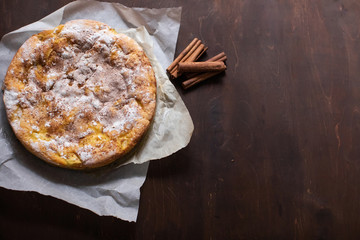 homemade apple pie with cinnamon on brown wooden table
