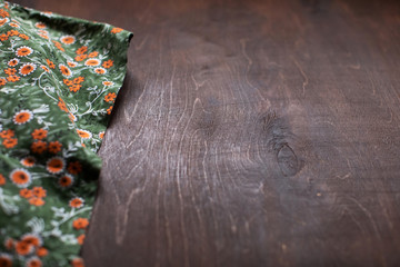 Flowery fabric on brown wooden table background