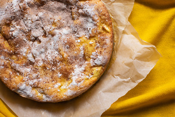 Delicious homemade pie with apples and cinnamon on yellow background