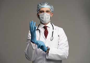 Male doctor man in white medical sterile face mask put gloves on hands. Coronavirus 2019-ncov sars covid-19 flu concept