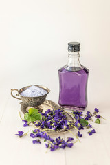 Obraz na płótnie Canvas close up viola violetta odorata skin care product fragrant lilac soap with lilac spa bath salts and tincture body oil