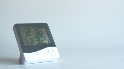 Digital thermometer on a white background. Hygrometer and clock. Alarm clock