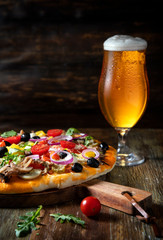 
Beer and homemade pizza on a wooden table