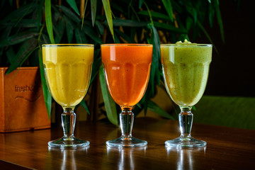 Orange, green, red colored smoothies freshly squeezed juice