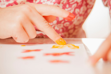 Close up child girl painting with colorful hands and finger.