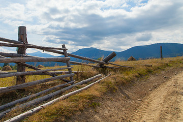 part of a wooden fence against the backdrop of Mount Petros. Carpathian landscape. Ukraine