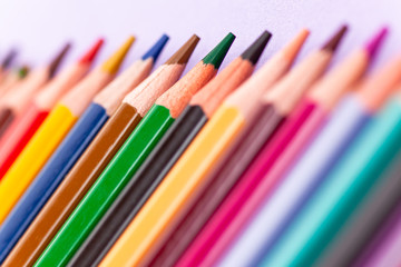 Fototapeta premium color pencils on purple background, close-up