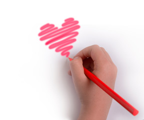 A hand with a pencil draws a heart in red.copyspace for text.