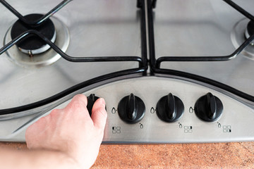 The man starts the gas stove. The concept of using gas to heat food, prepare dishes. Natural gas...