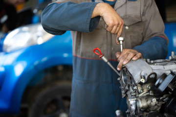 Fototapeta na wymiar An auto mechanic repairs an internal combustion engine