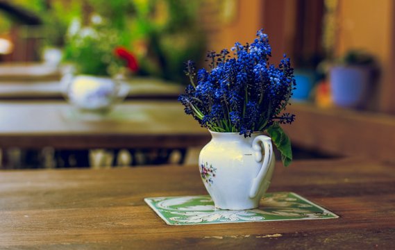 Vase With Blue Flowers On Table