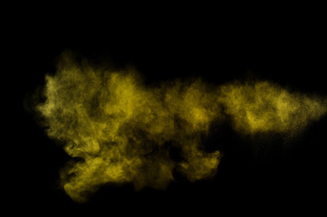 Yellow powder explosion.Yellow powder explosion on black background. Colored powder cloud. Colorful dust explode. Paint  Holi.