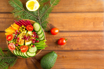 vegan salad with avocado and pomegranate  on a wooden table, concept of vegan and healthy food