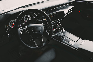 Interior of an ultra modern new luxury car. Leather chairs and wood trim, touch panels with...