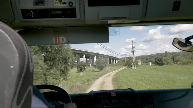 Tourist passenger's point of view from a tour bus coach driving down a bumpy road in Albufeira, Portugal.