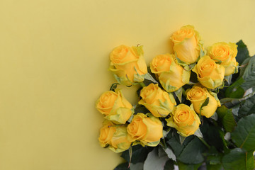 A bouquet of fresh yellow roses flowers with leaves on an isolated background. Flat lay, top view. corner composition. postcard birthday floral arrangement