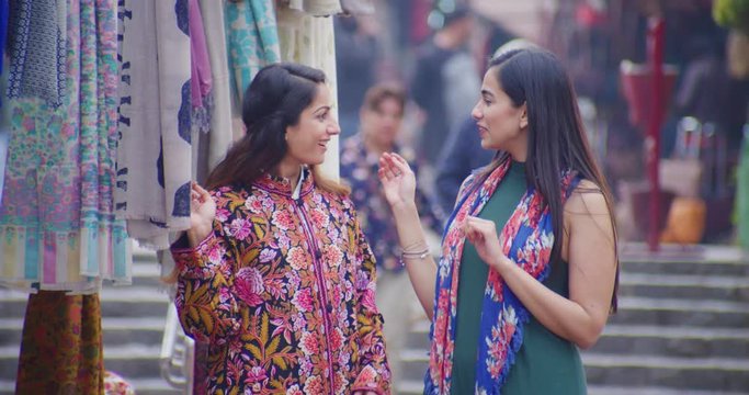 4K Happy young Indian friends shopping for clothes in street market Slow motion.