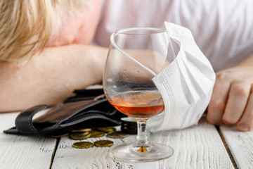 covering a glass of alcohol with medical face mask. Concept of cancelled social events during pandemic and corona virus quarantine