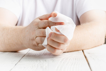 Close up on midsection of man hands wiping using white alcohol tissue cleaning napkin disinfection from virus and bacteria in day at home or office