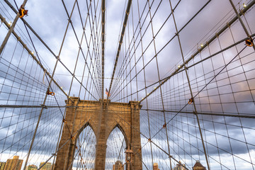 The  Brooklyn Bridge at sunset, major pylon and cables against cloudy sky