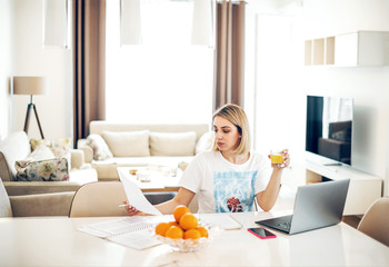 Fototapeta na wymiar Young woman working from home at kitchen table.