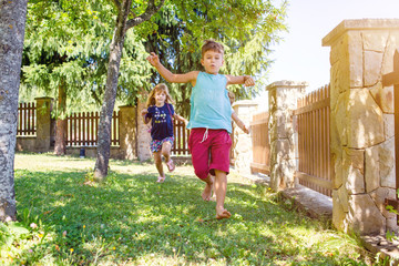 Two girls, sisters and their boy friend running in the park, outdoors