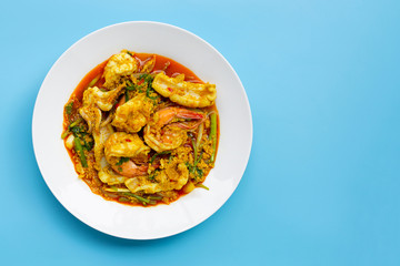 Fried seafood with curry powder on blue background.