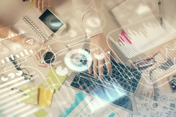 Double exposure of man's hands typing over computer keyboard and tech theme hologram drawing. Top view. Technology concept.