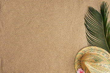 Fototapeta na wymiar Summer vacation composition. Palm leaves anf straw hat on sand background