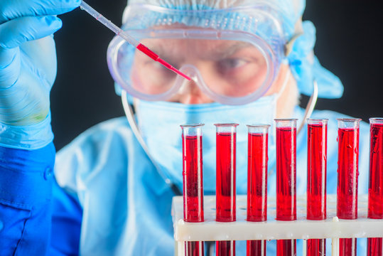 Blood research. Doctor works with blood sample. Scientist make test in laboratory. Laboratory equipment. Experienced scientist doing research in lab. Medical worker make blood test.