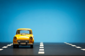 Yellow toy car on a blue background.