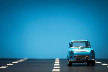 Fototapeta na wymiar Blue toy car on an asphalt road.