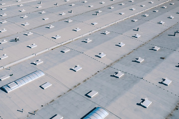 Large roof of factory with roof ventilators, drone shot from above