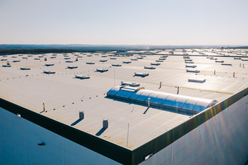 Large roof of factory with roof ventilators, drone shot from above - Powered by Adobe
