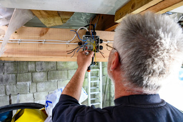 British welsh male wiring a junction box at home doing diy in garage