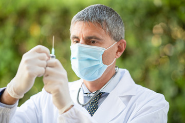 Confident male doctor weraing mask for covid-19 coronavirus outbreak. View in uniform with...