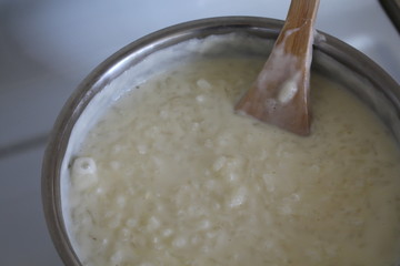Cooking of rice porridge on oven, the first stage of preparation of national Finnish dish from rye flour and rice - Karelian pies